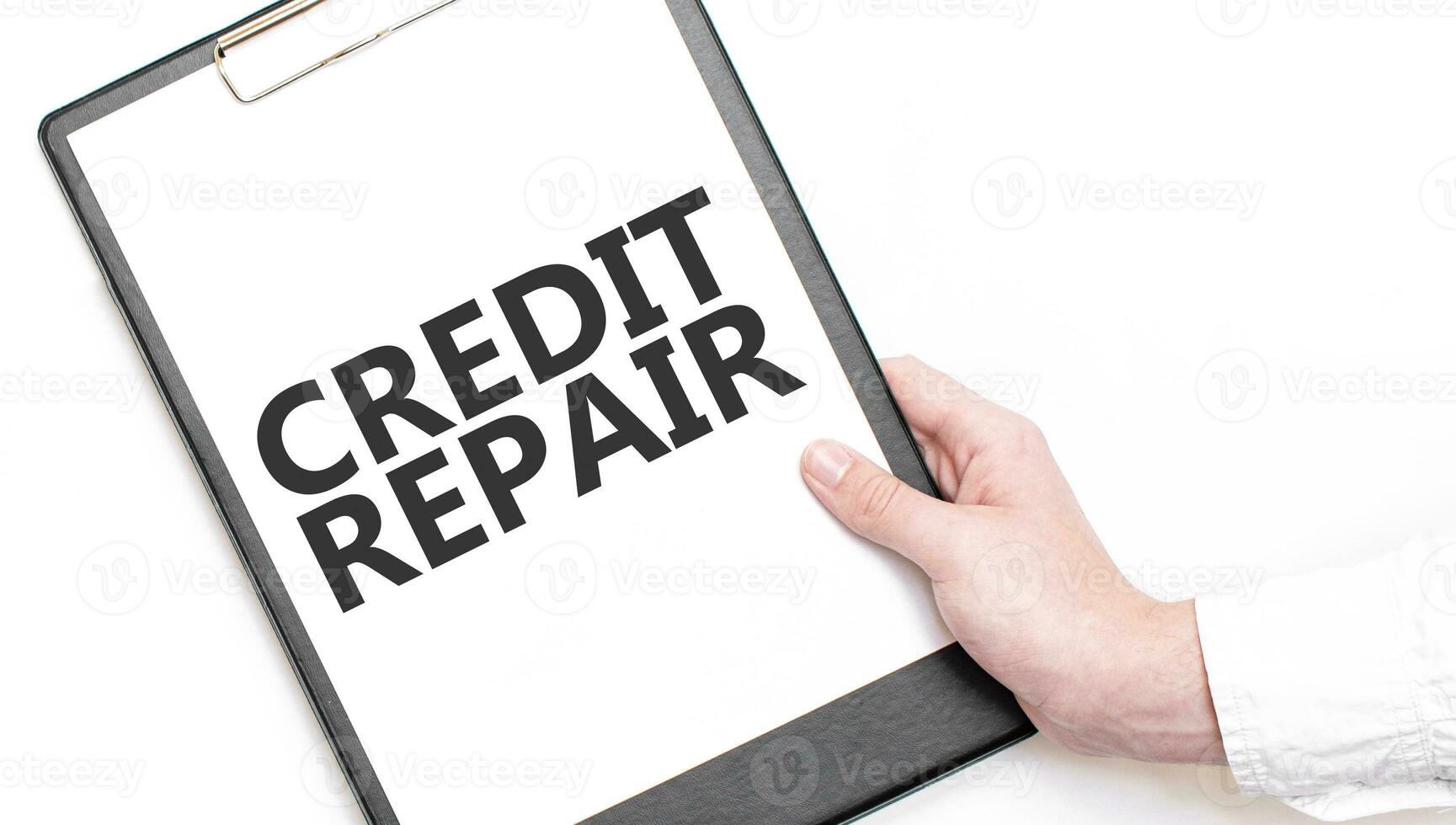 A businessman holds a folder with paper sheet with the text CREDIT REPAIR. Business concept. photo