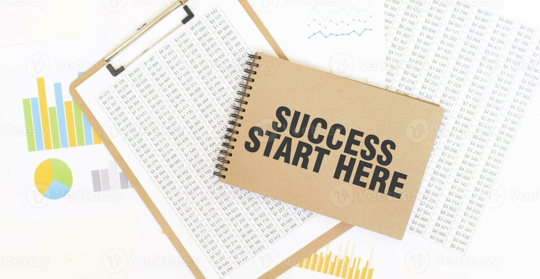 Text SUCCESS START HERE on brown paper notepad on the table with diagram. Business concept photo
