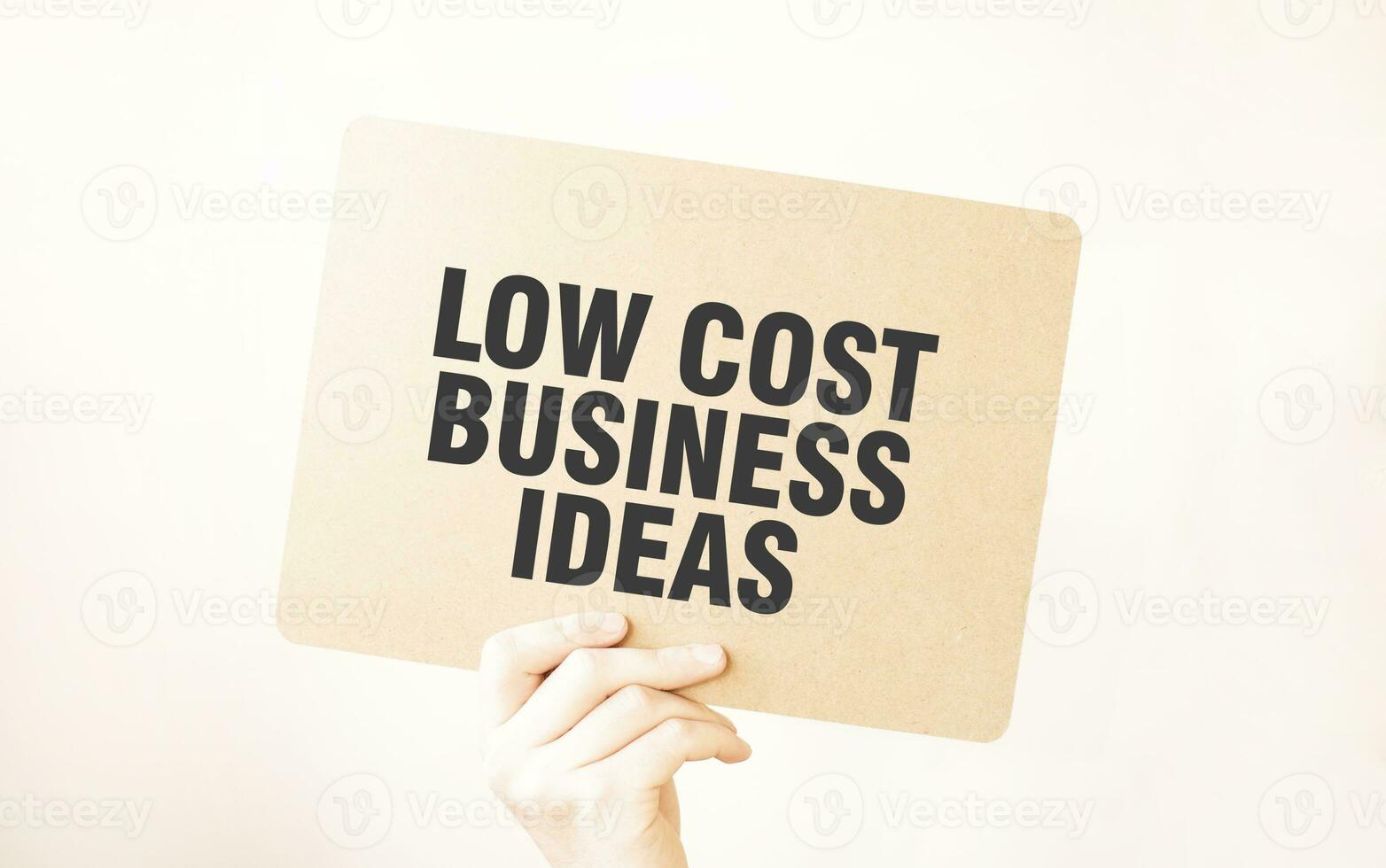 Closeup Business man hand holding show blank paper sheet mock up LOW COST BUSINESS IDEAS photo
