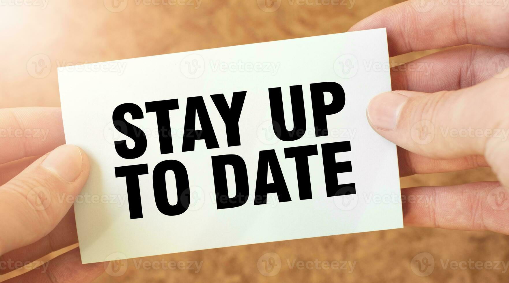 STAY UP TO DATE word inscription on white card paper sheet in hands of a businessman. recap concept. red and white paper photo