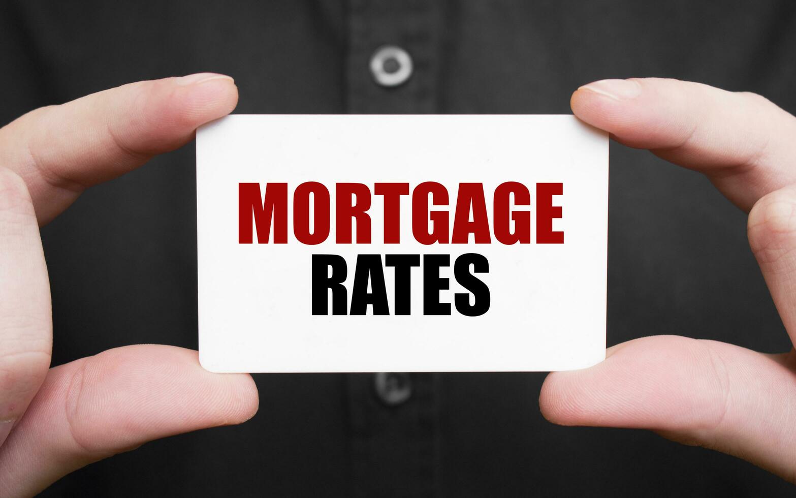 Businessman holding a card with text MORTGAGE RATES, business concept photo