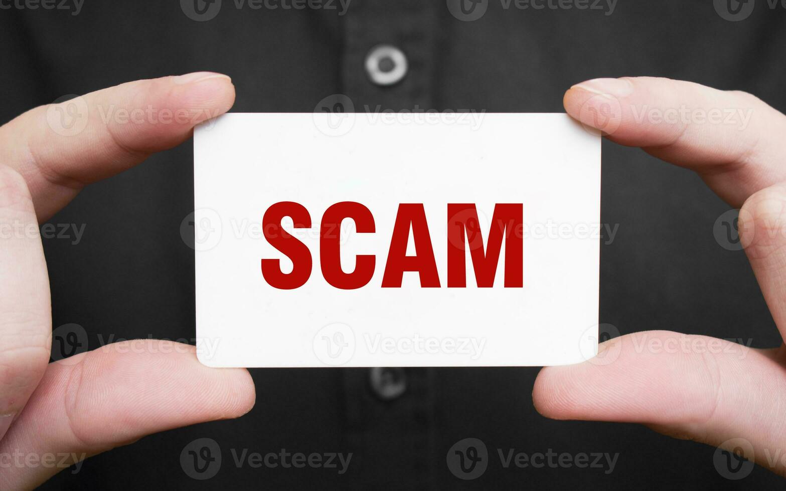 Businessman holding a card with text SCAM, business concept photo