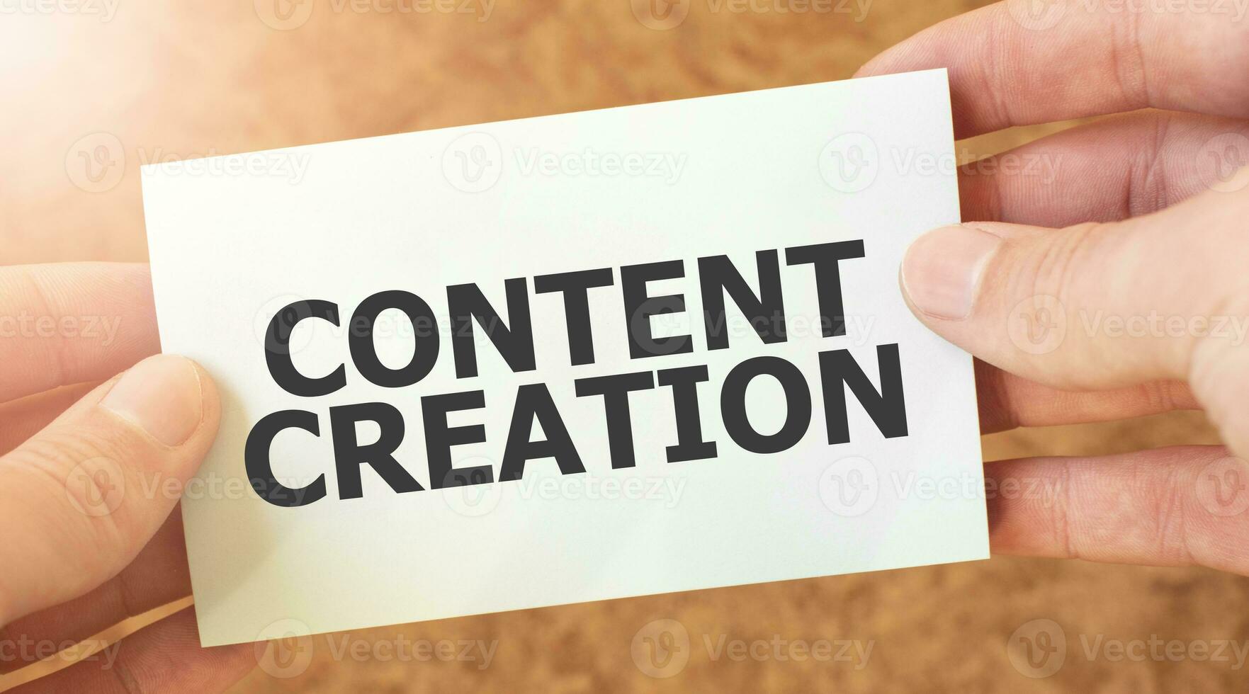 CONTENT CREATION word inscription on white card paper sheet in hands of a businessman. photo