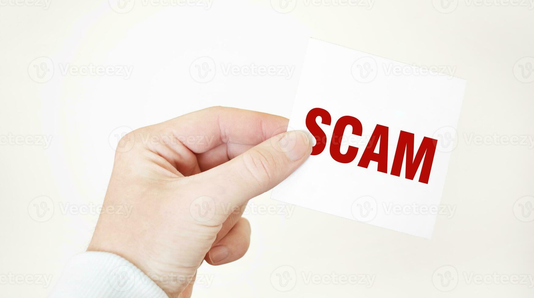 Businessman holding a card with text SCAM ,business concept photo