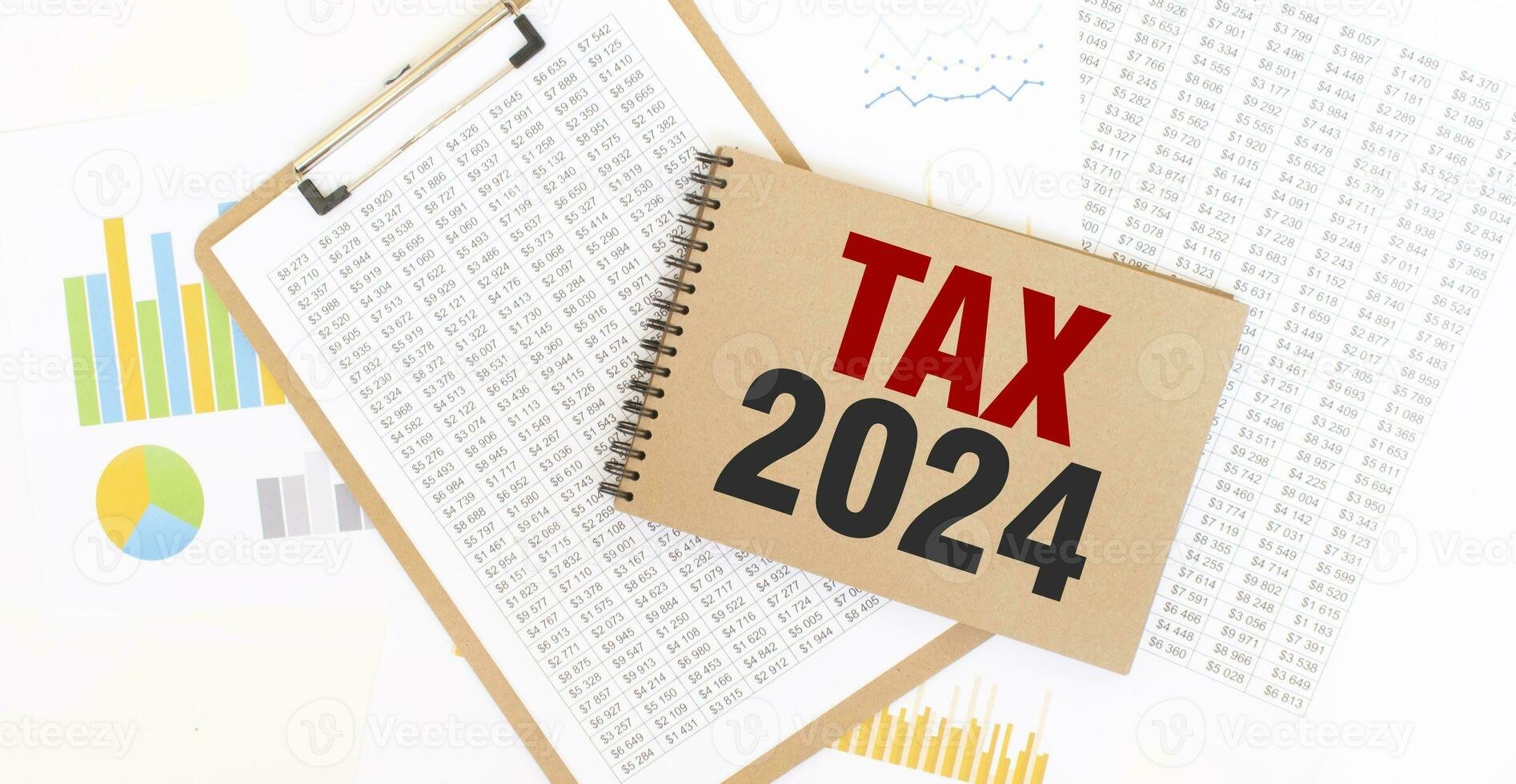 Text TAX 2024 on brown paper notepad on the table with diagram