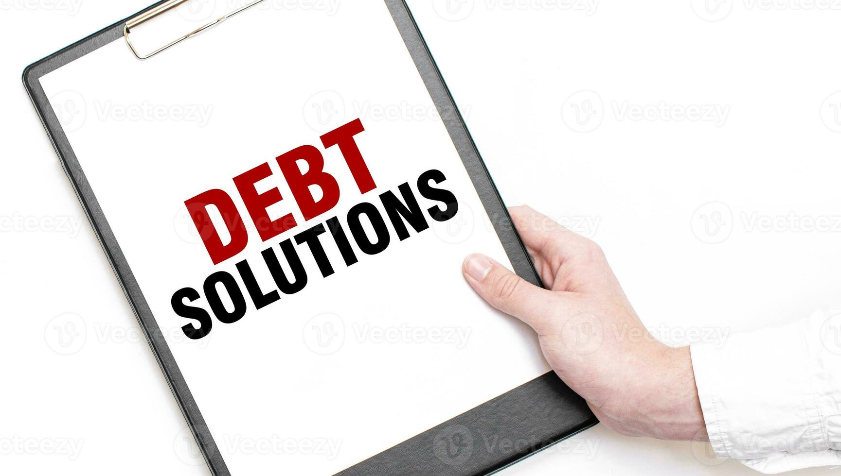 A businessman holds a folder with paper sheet with the text DEBT SOLUTIONS. Business concept. photo