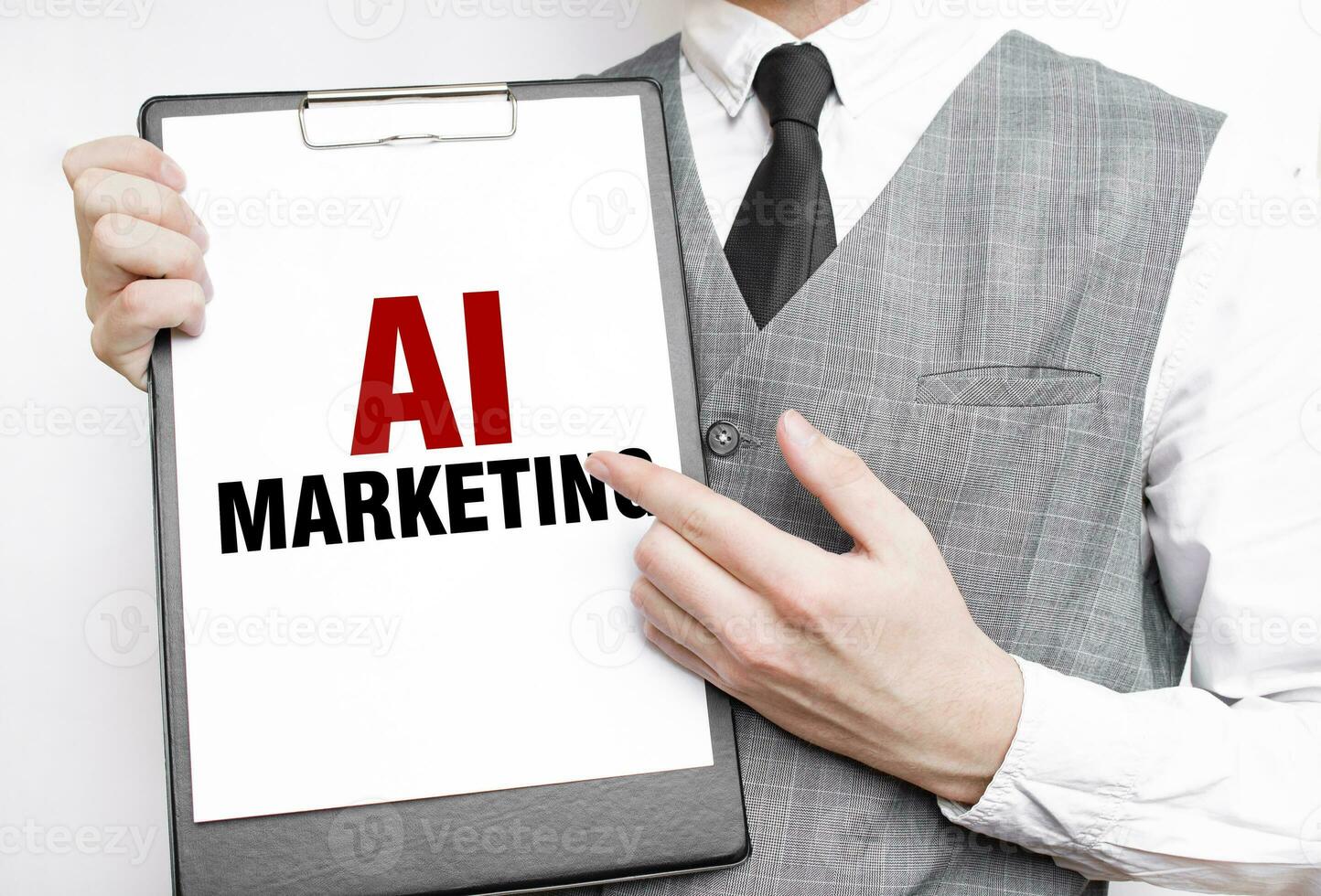AI MARKETING inscription on a notebook in the hands of a businessman on a gray background, a man points with a finger to the text photo