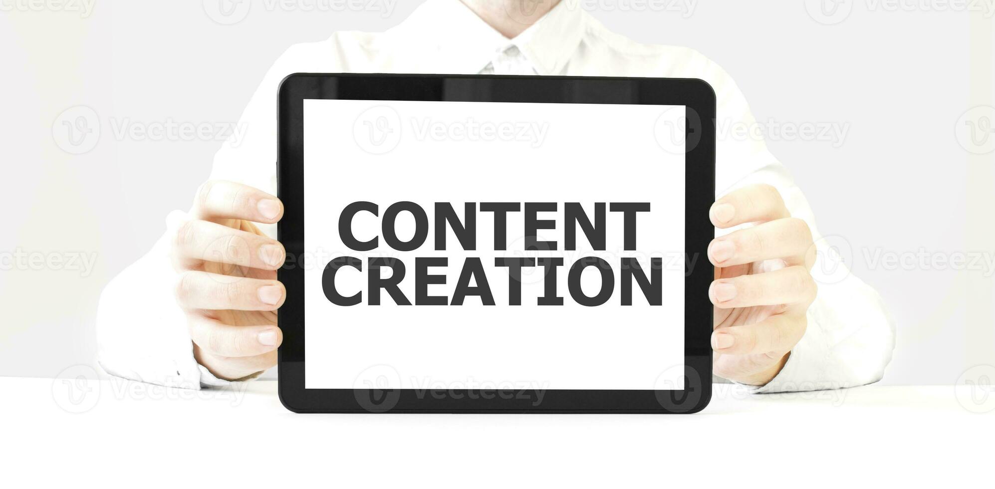 Text CONTENT CREATION on tablet display in businessman hands on the white background. Business concept photo