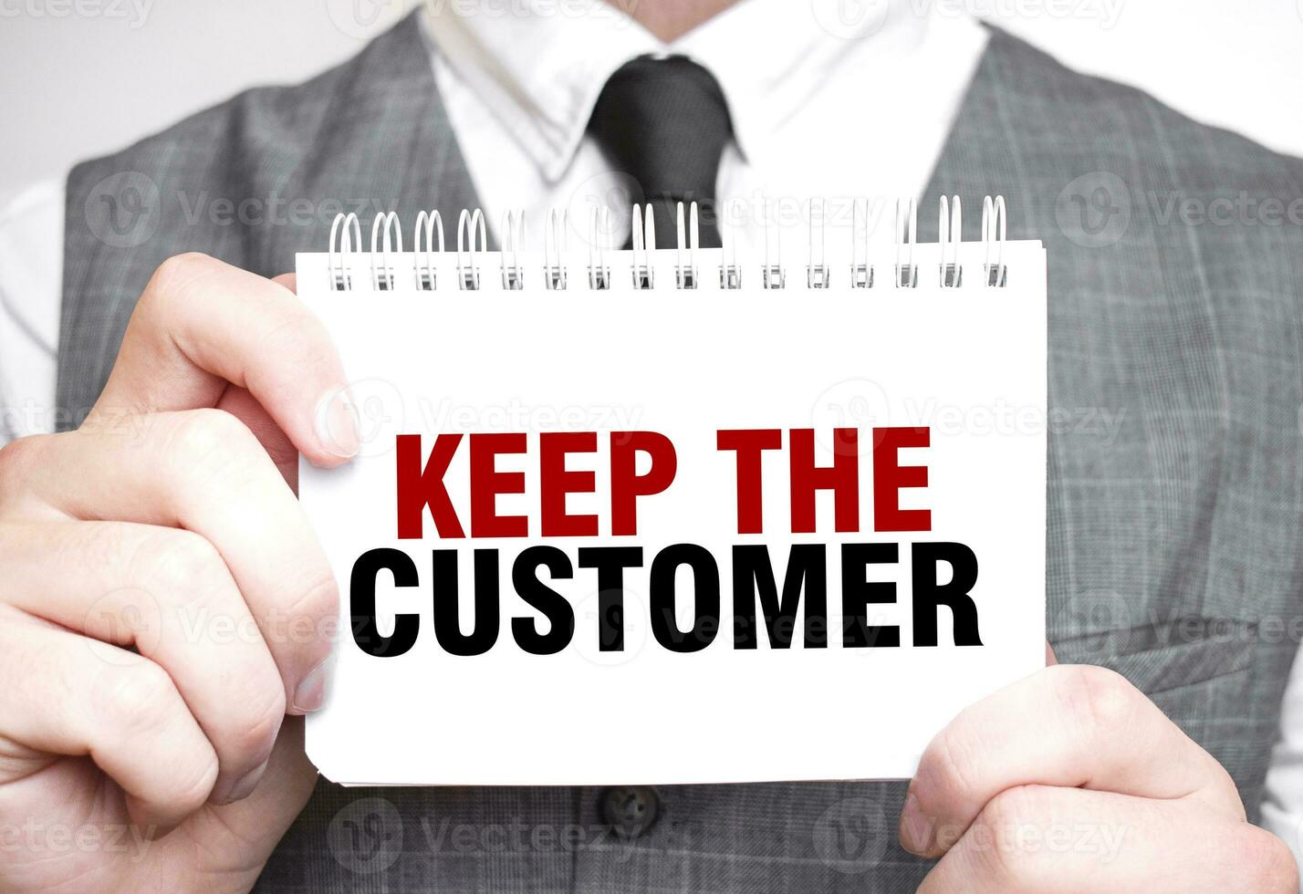 Businessman with notebook with text KEEP THE CUSTOMER photo