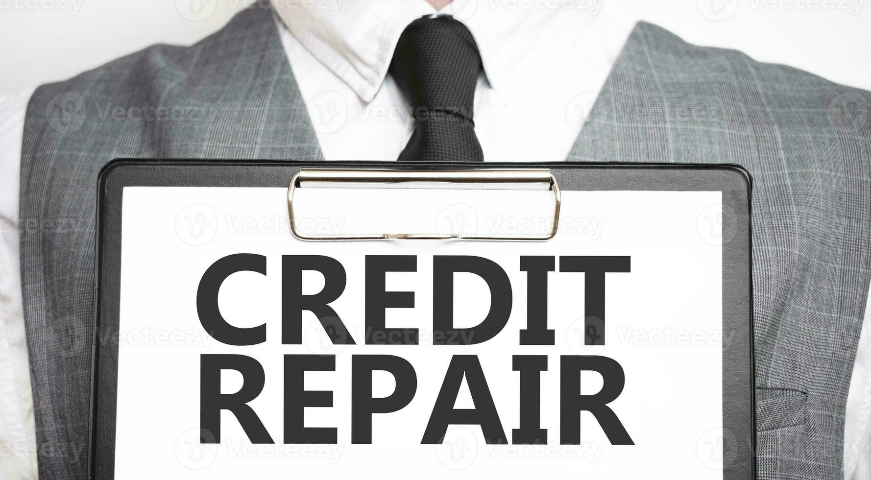 Businessman holding sheet of paper with a message CREDIT REPAIR photo