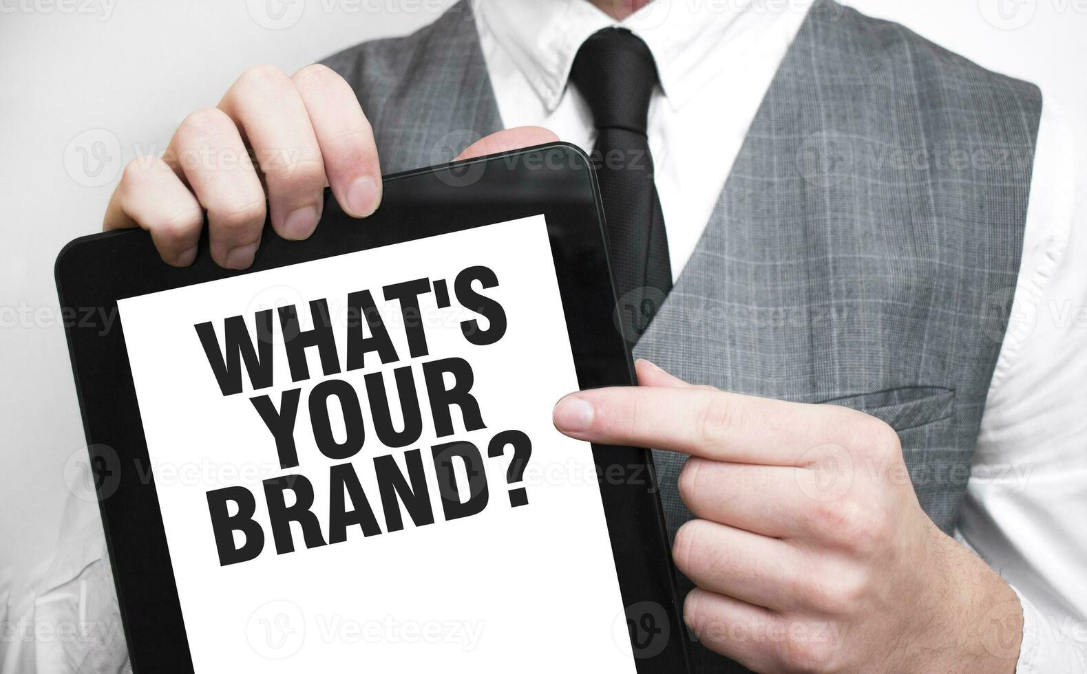 Businessman showing business concept on tablet standing in office WHAT's your brand photo