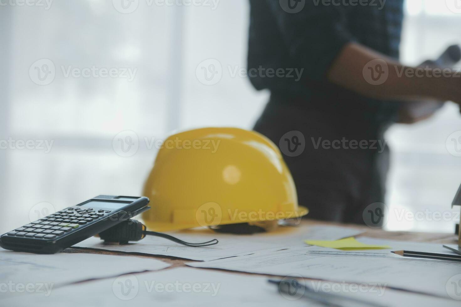 Close up of civil male engineer asian working on blueprint architectural project at construction site at desk in office. photo