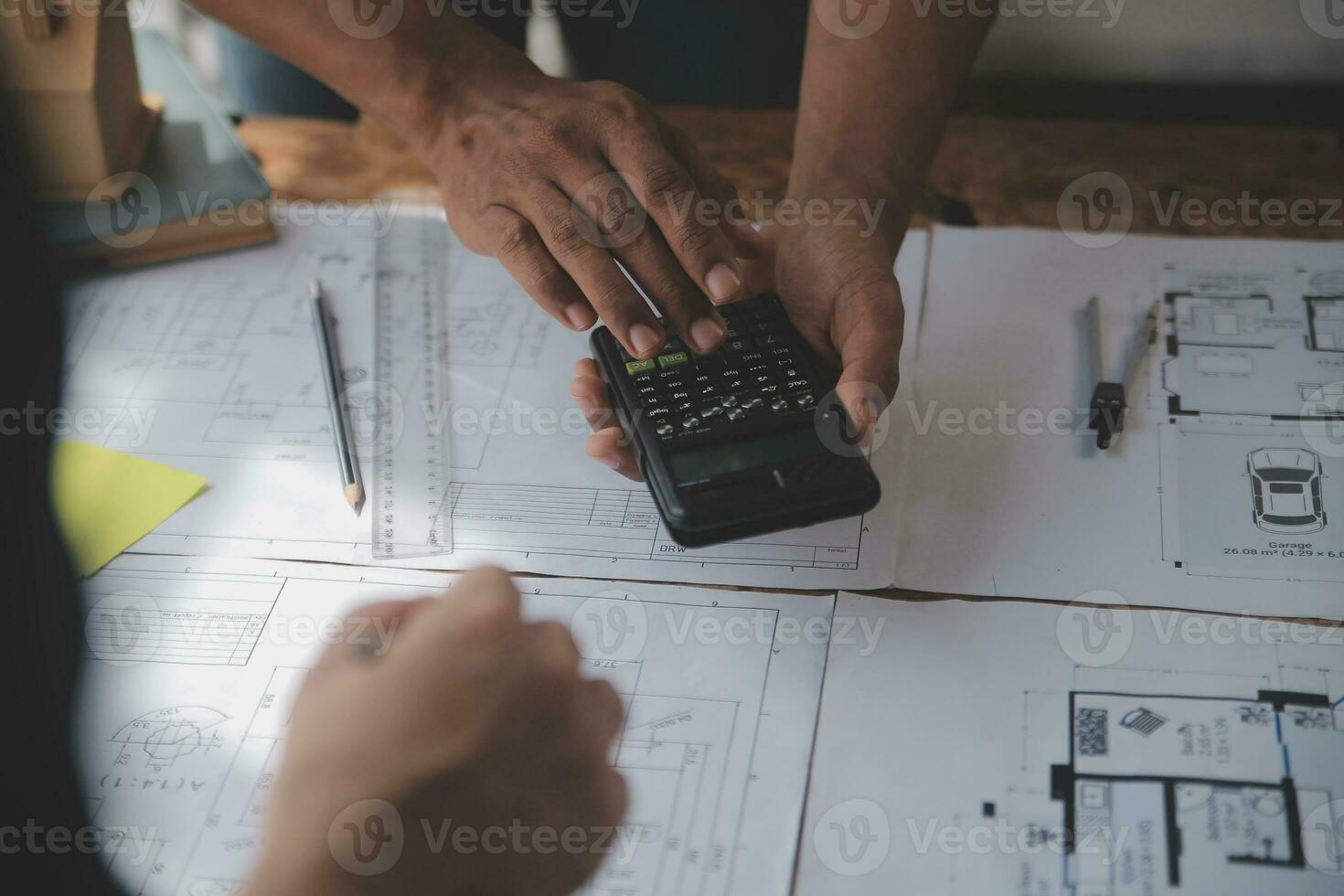 Close up of civil male engineer asian working on blueprint architectural project at construction site at desk in office. photo