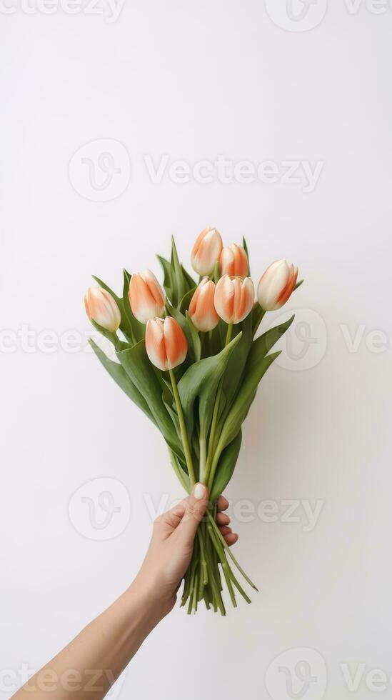 Hand holding a beautiful bouquet of tulip flowers. Isolated on a light wall background. AI Generated photo
