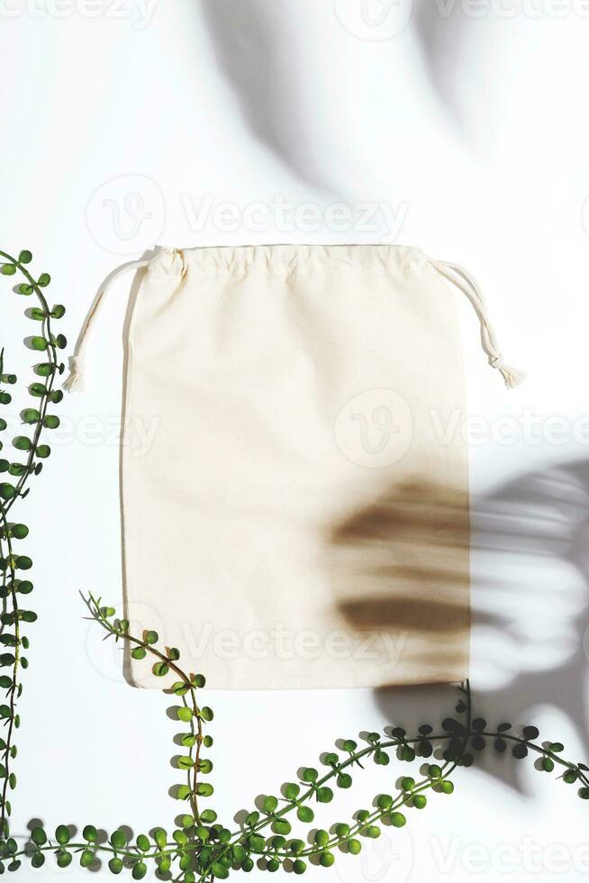 Reusable Eco bag mock up for zero waste shopping among green leaves and shadows. Minimal flat lay. photo
