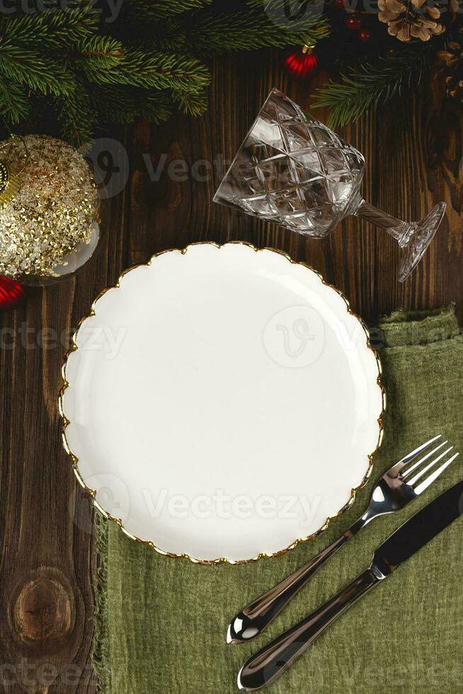 Empty white plate mock up at served Christmas table among decorations. Top view layout. photo
