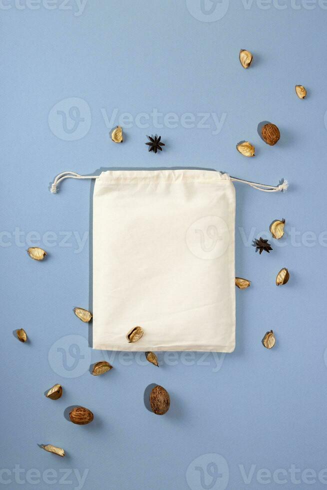 Reusable Eco bag mock up for zero waste shopping on blue background with eco decorations. Minimal flat lay. photo