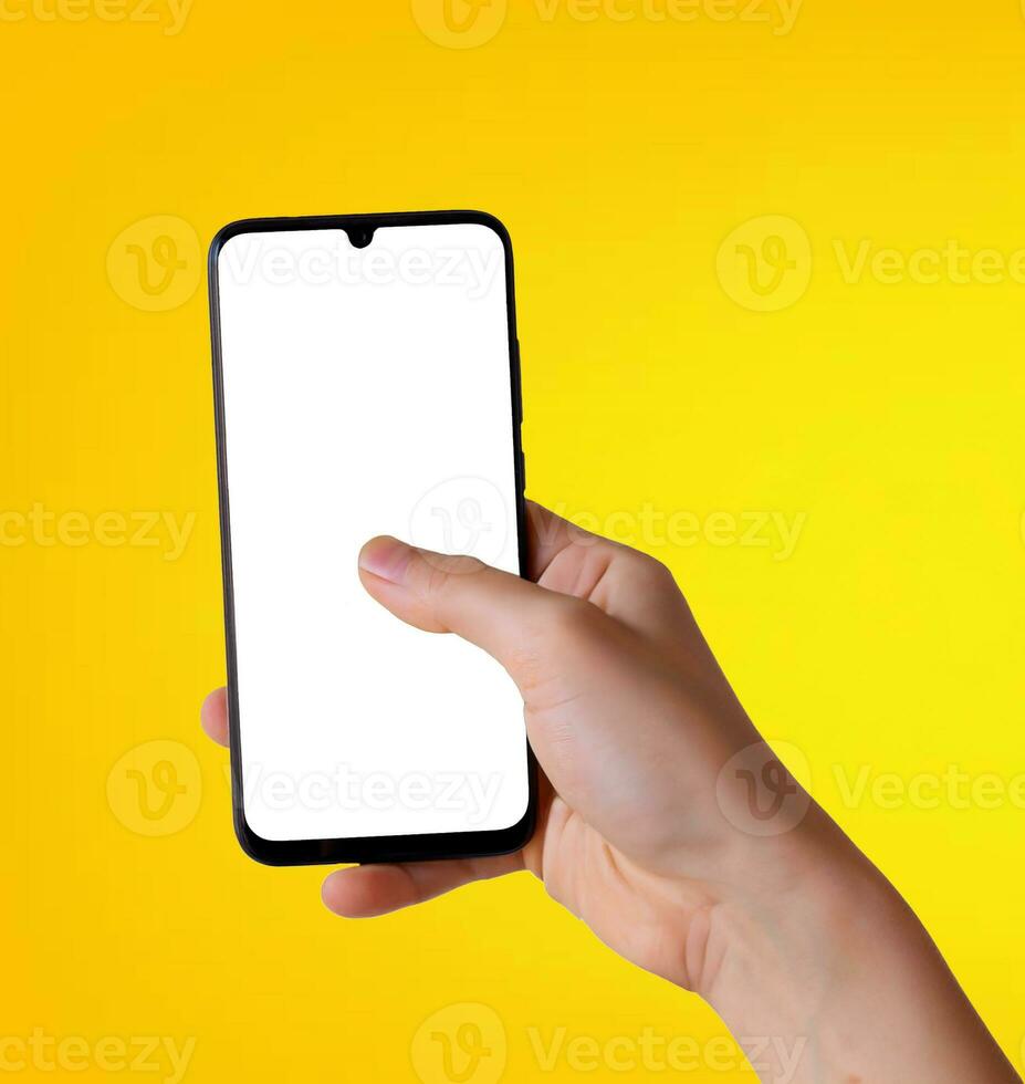 Smartphone with a white screen in hand on a yellow background. photo