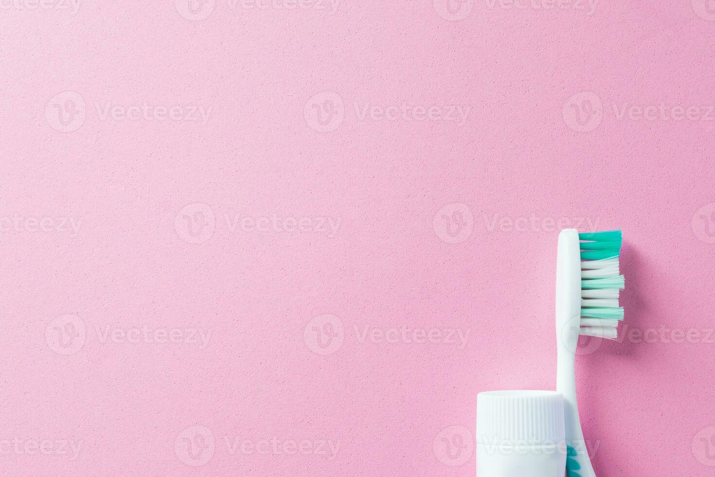 Toothbrush and toothpaste on beautiful pink background with copy space for design. Lifestyle and daily routine for healthy mouth and teeth with cleaning tools for oral and dental health care. photo