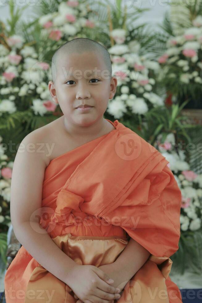 portrait of buddhist novice wearing thai monk clothes standing outdoor photo