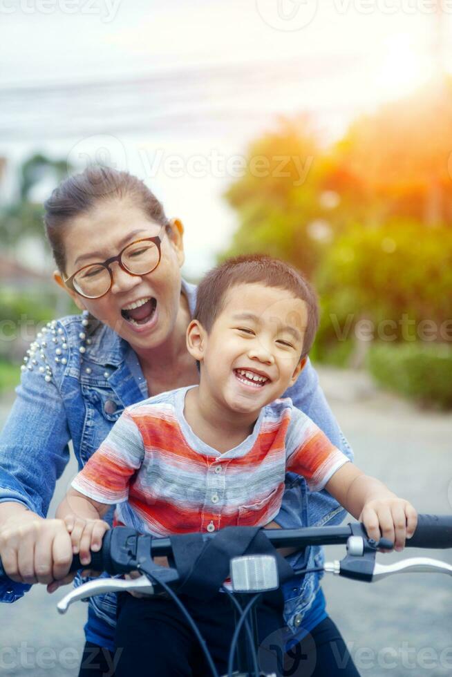 portrait of asian children riding bicycle with mother smiling face happiness emotion photo