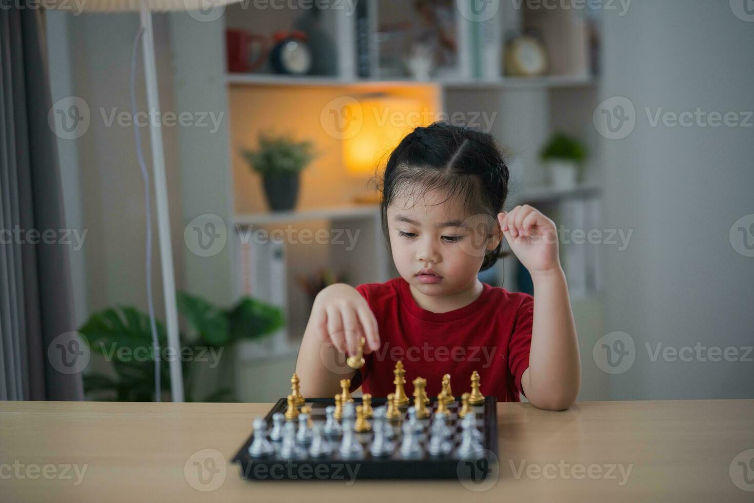 Education studying concept. Little cute asian baby girl children playing chess in the living room at home.Smart kid.fashion children. Little genius Child. Intelligent game.Chessboard. photo