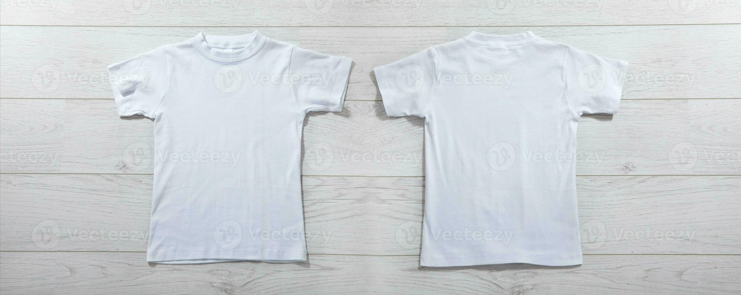 Front and back views on boys t-shirts on white wooden desk background. Mockup for design closeup photo