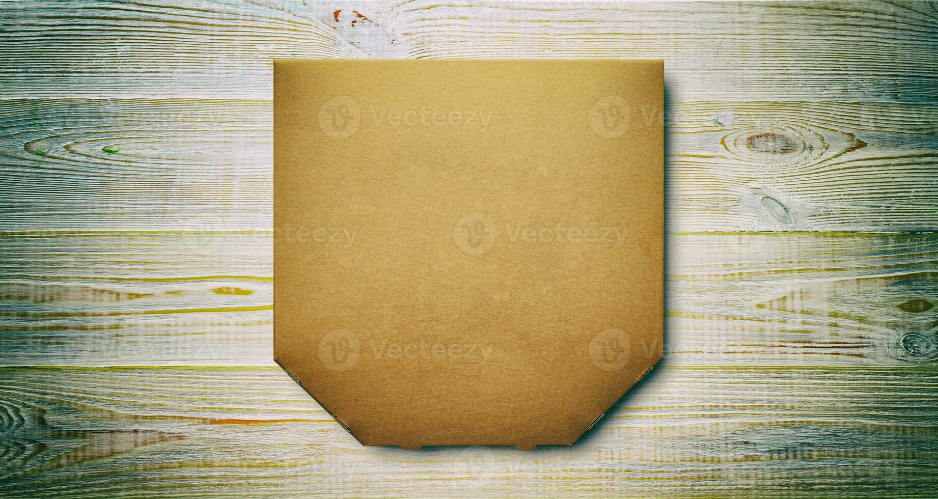 Box of cardboard pizza, blank unprinted on wooden background, mockup top view photo