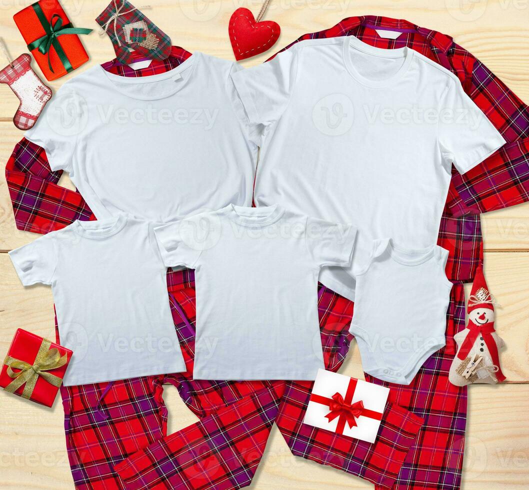 Blank white t-shirts for the whole family on the background of bright pajamas on a wooden background with Christmas presents photo