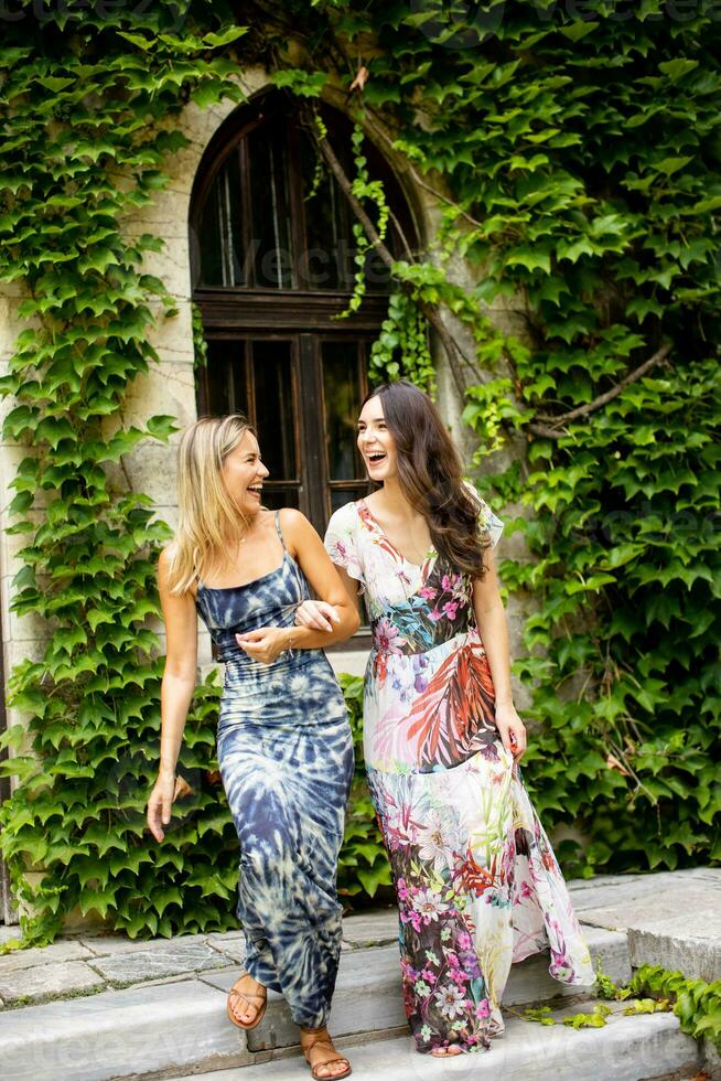 Pretty young women walking by the old house with ivy photo