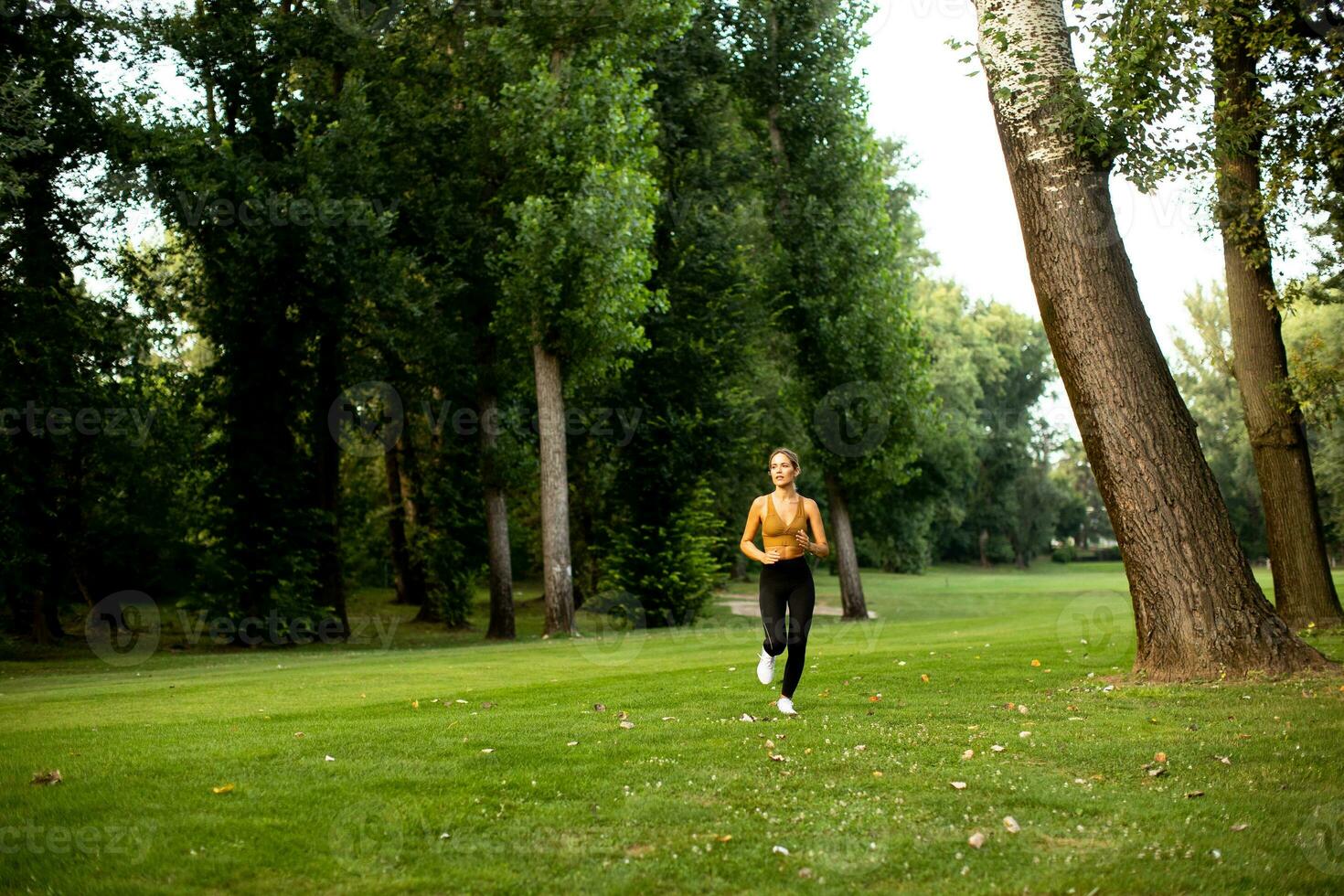 Pretty young woman running in the park photo