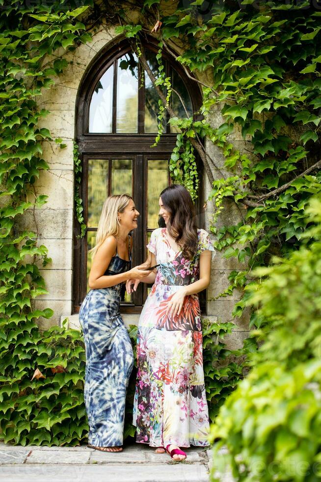 Pretty young women using mobile phone by the old house with ivy photo