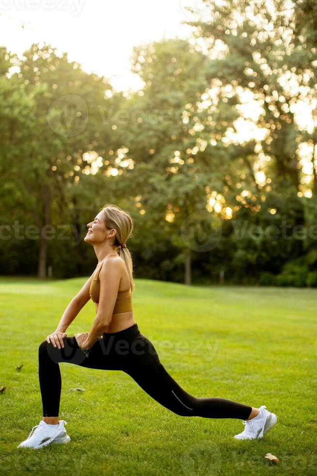 Pretty young woman stretching in the park photo