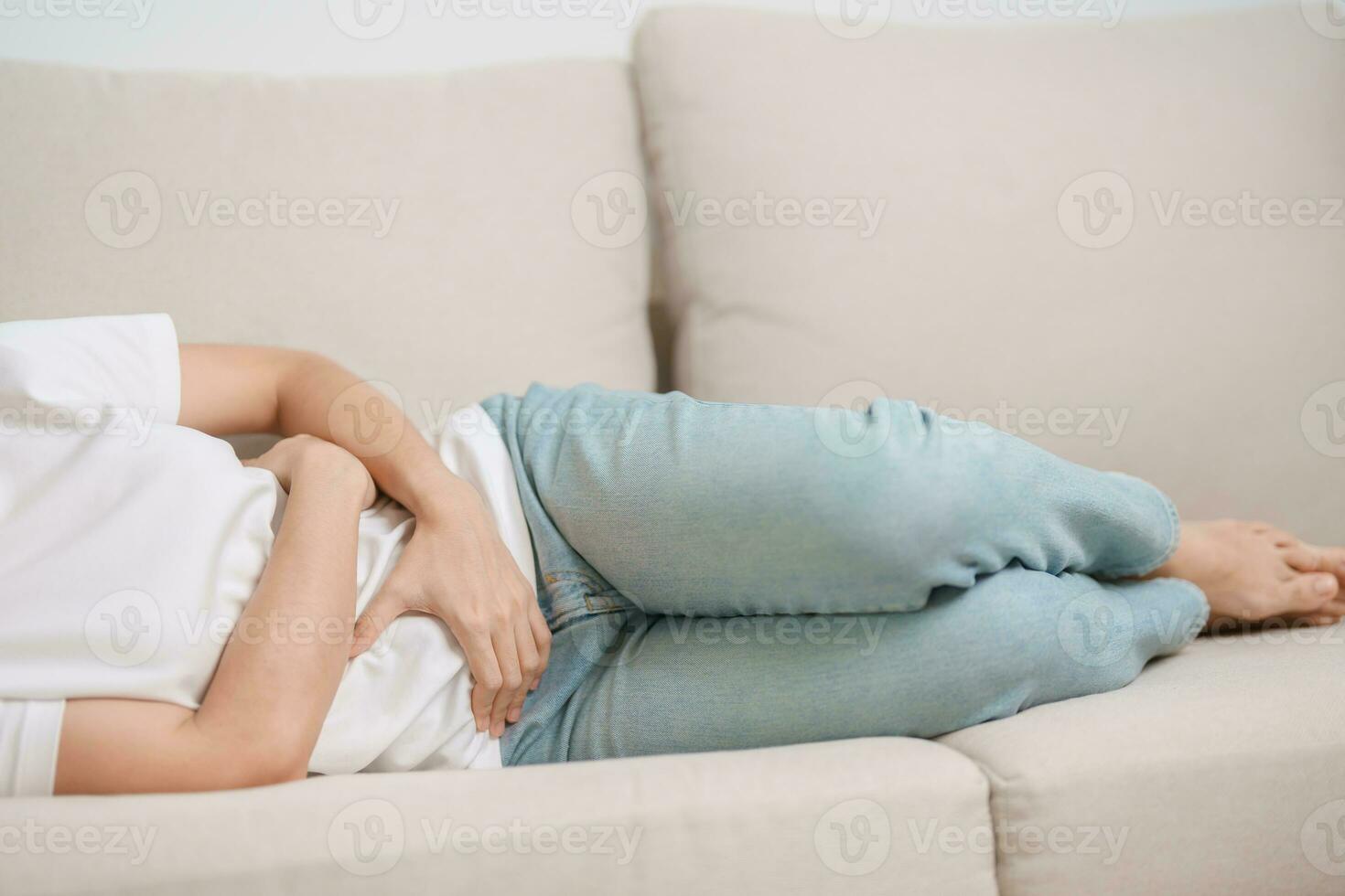 woman having abdomen ache due to Stomach pain, digestion with constipation or Diarrhea from food poisoning, female problem and Endometriosis, Hysterectomy and Menstrual on the sofa at home photo