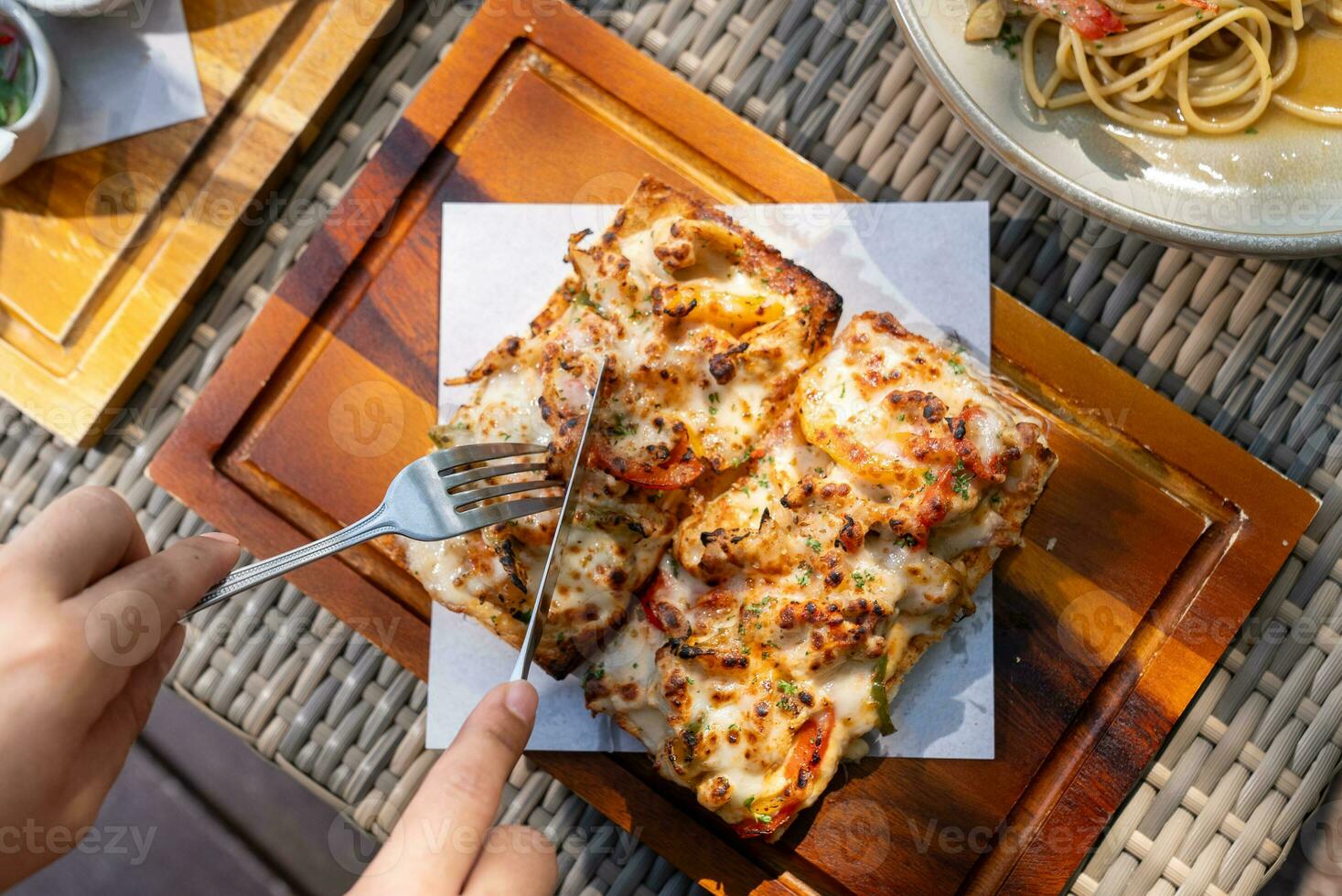 Spaghetti, pizza, french fries, beef steak on a wooden plate on the beach photo