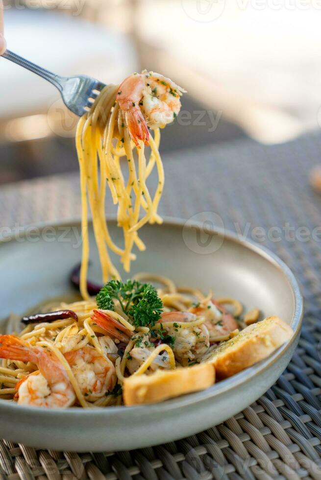 Spaghetti, pizza, french fries, beef steak on a wooden plate on the beach photo
