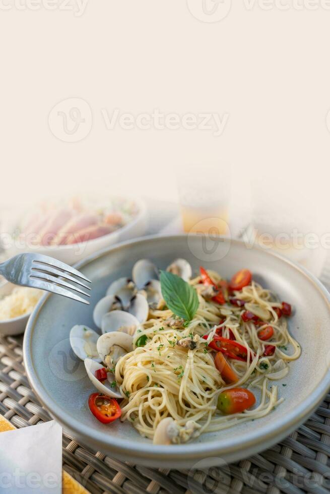 Spaghetti, pizza, french fries, beef steak on a wooden plate on the beach photo