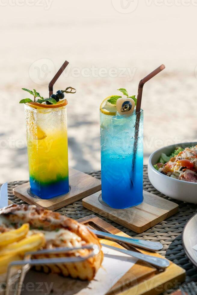 Colorful cocktails in pretty glasses on the beach photo