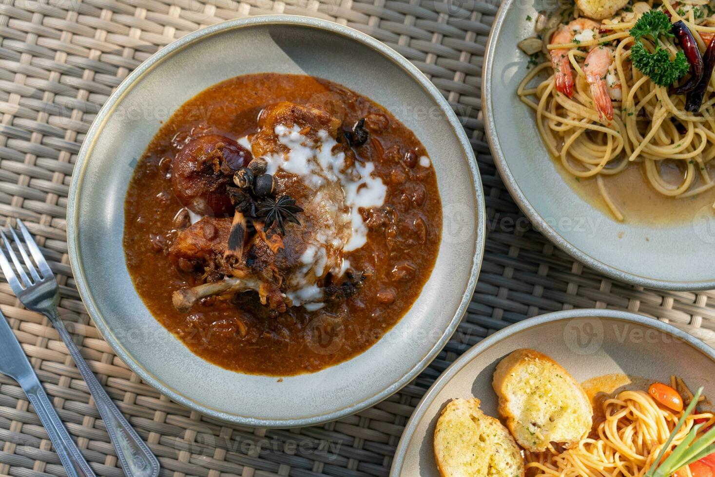 Spaghetti, pizza, french fries, beef steak on a wooden plate on the beach photo