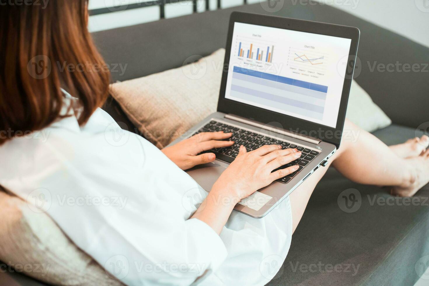 joven mujer trabajando en ordenador portátil computadora mientras sentado a el vivo habitación. trabajo desde hogar concepto foto