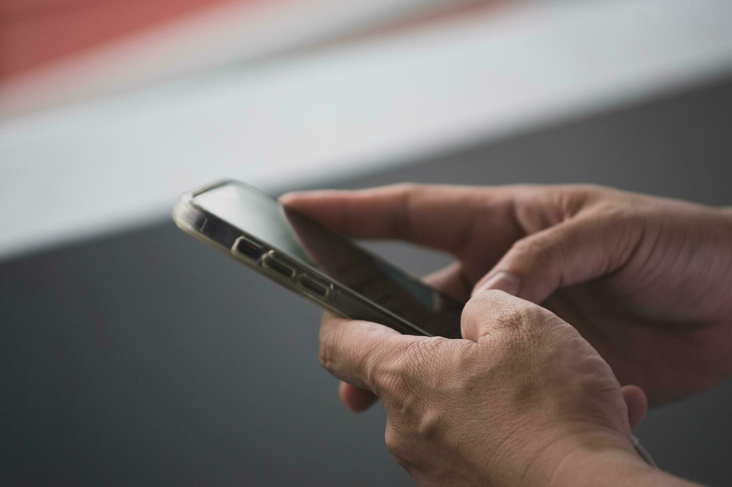 He held a smartphone in his hand and was typing a chat message with a friend. photo