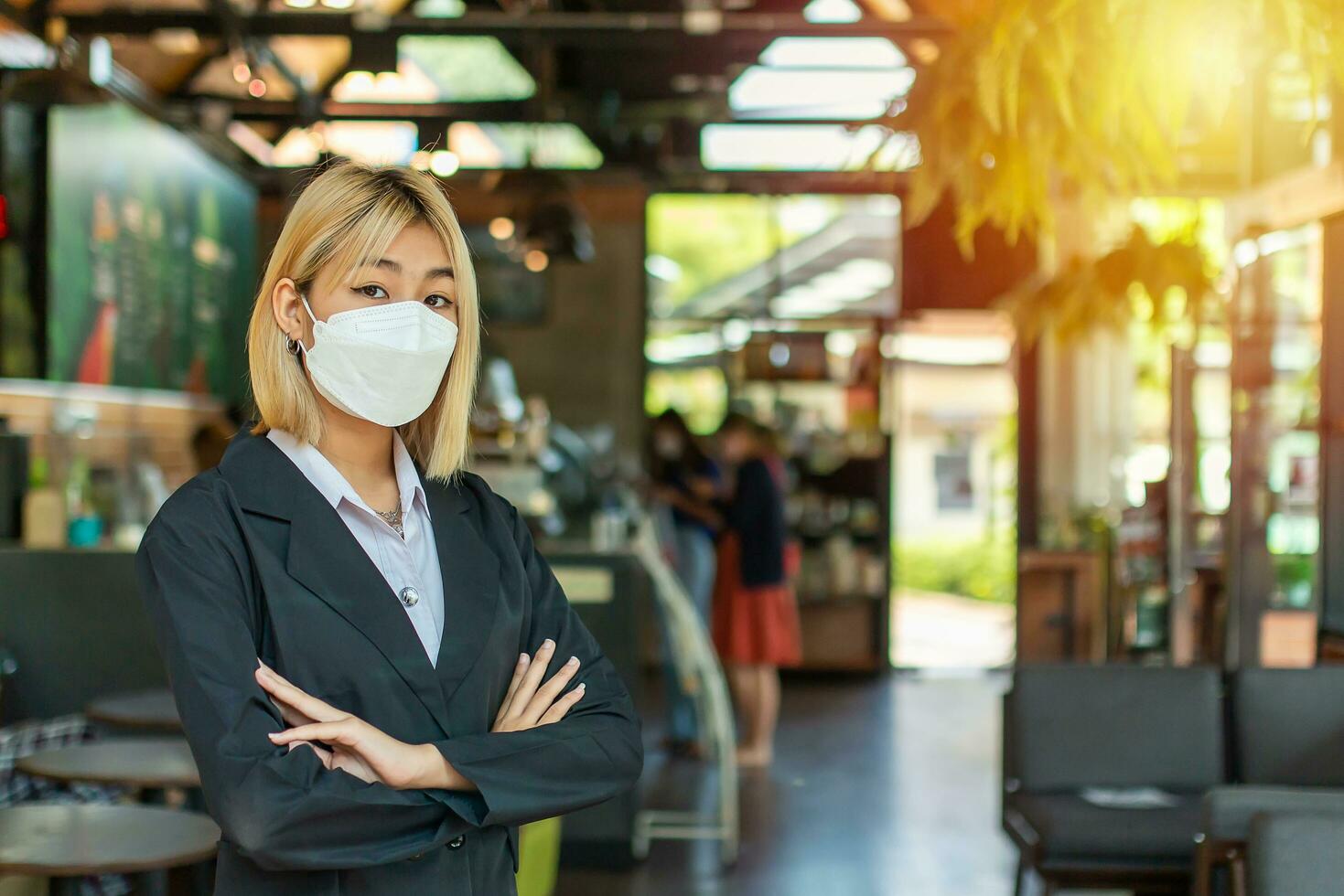 An image of a business owner standing in front of the cafe shop with arms crossed with a stern look. photo