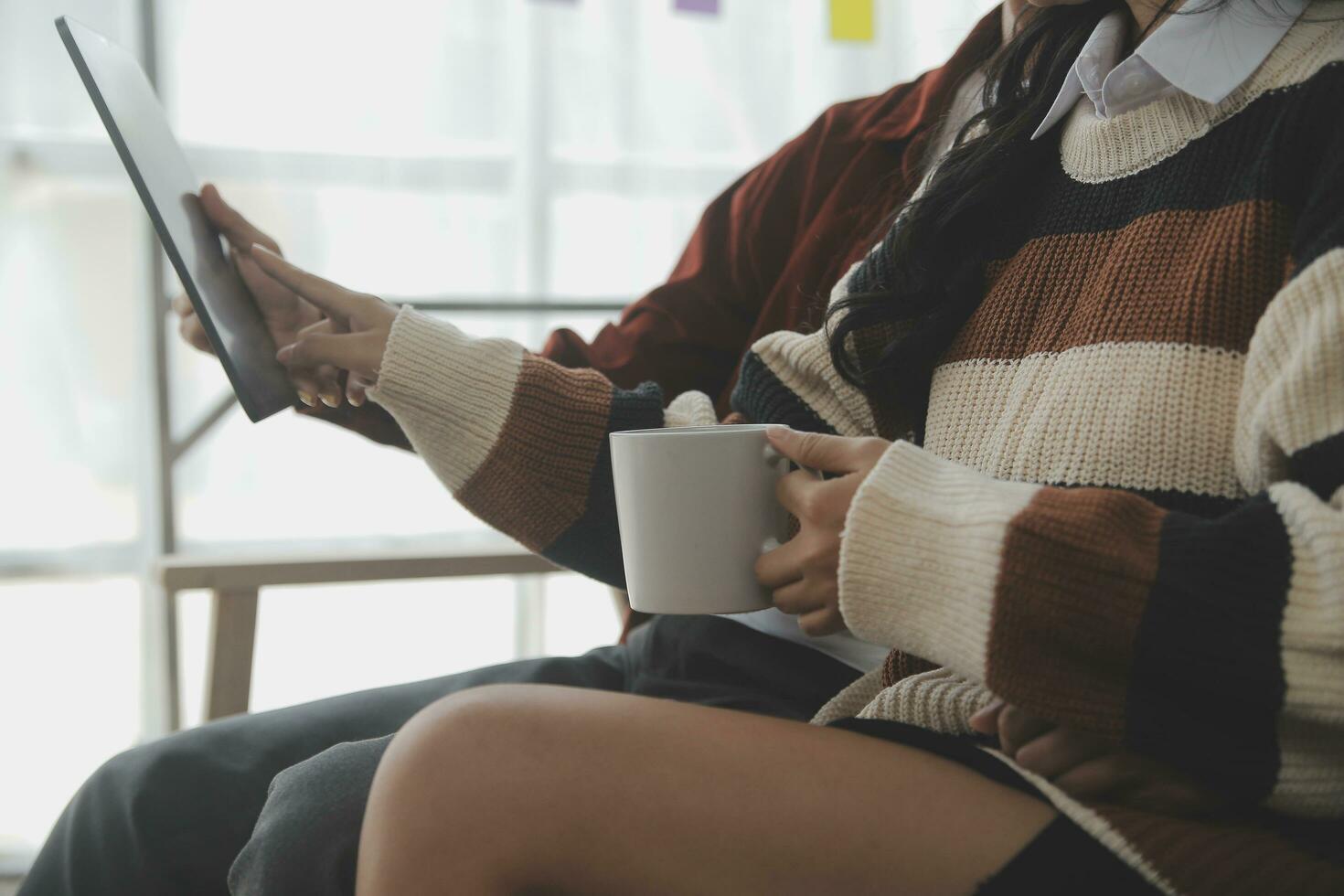 Young woman and young man using laptop while sitting by the sofa at home photo