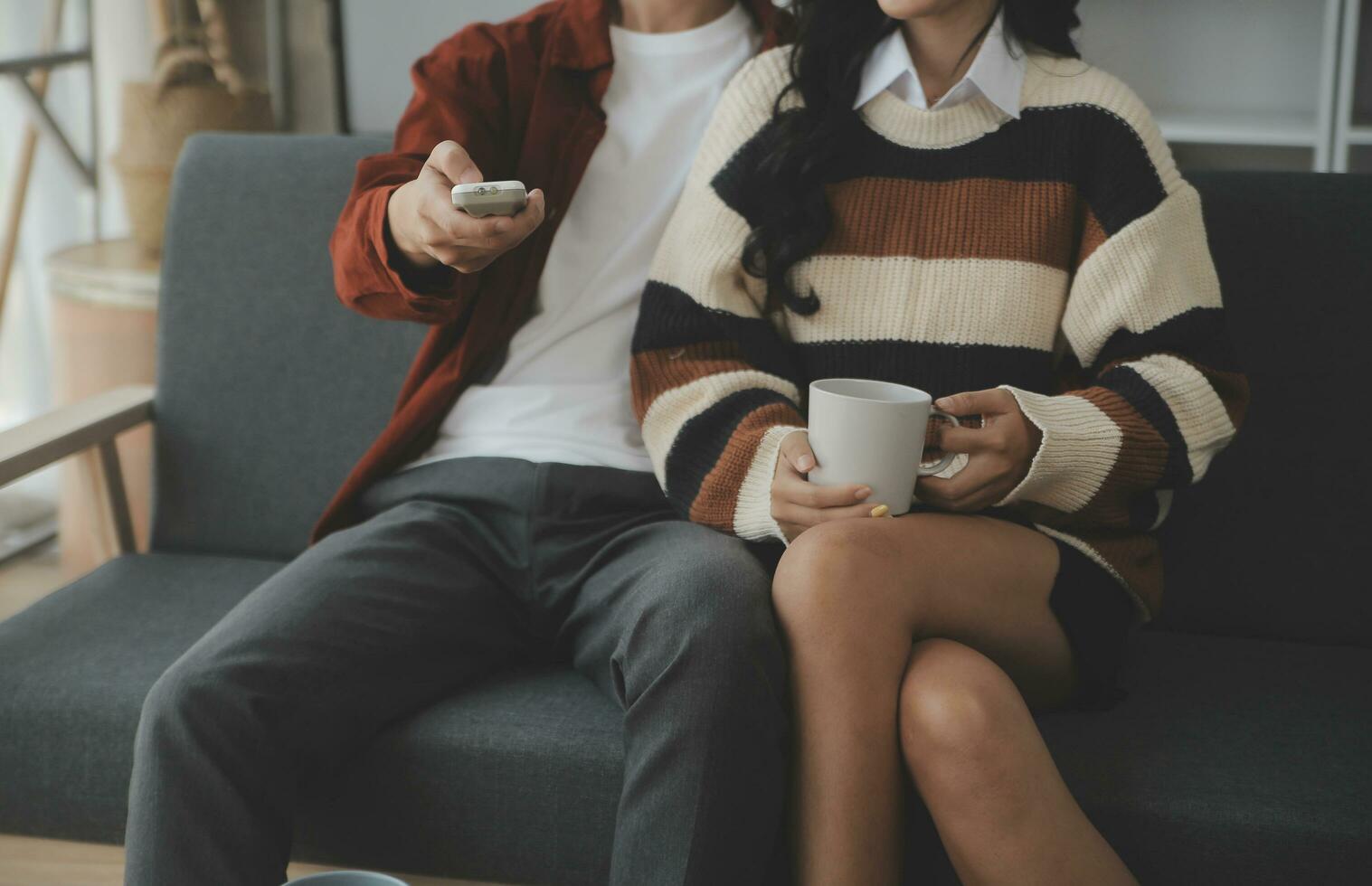 Young woman and young man using laptop while sitting by the sofa at home photo