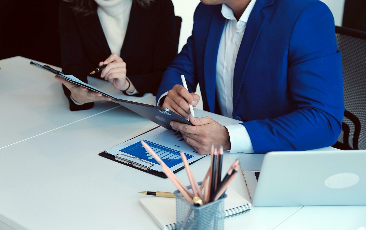 empresario empresario asiático y mujer de negocios discutiendo un nuevo proyecto de negocios en tableta en una reunión moderna en una oficina moderna, concepto casual de negocios asiáticos. foto