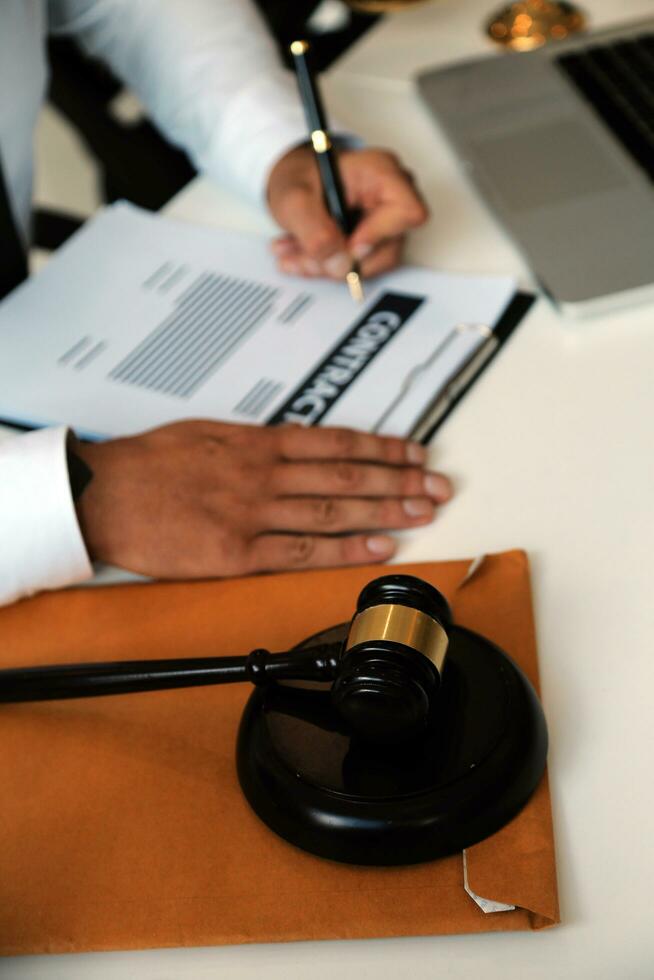 Judge gavel with Justice lawyers having team meeting at law firm in background. Concepts of law. photo