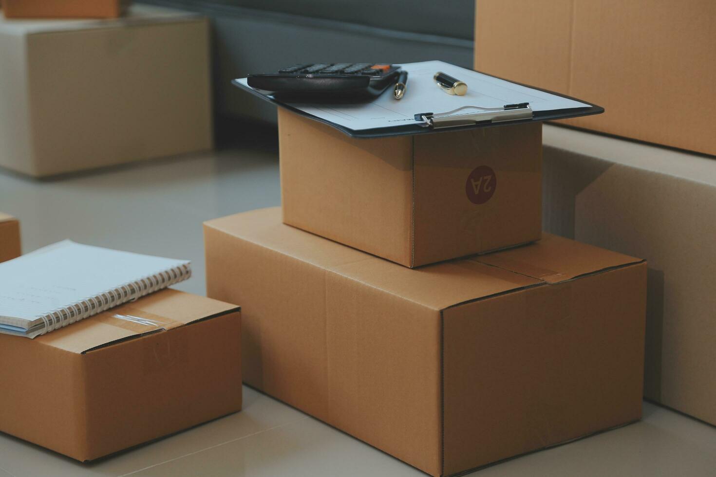 Startup SME small business entrepreneur of freelance Asian woman using a laptop with box Cheerful success Asian woman her hand lifts up online marketing packaging box and delivery SME idea concept photo