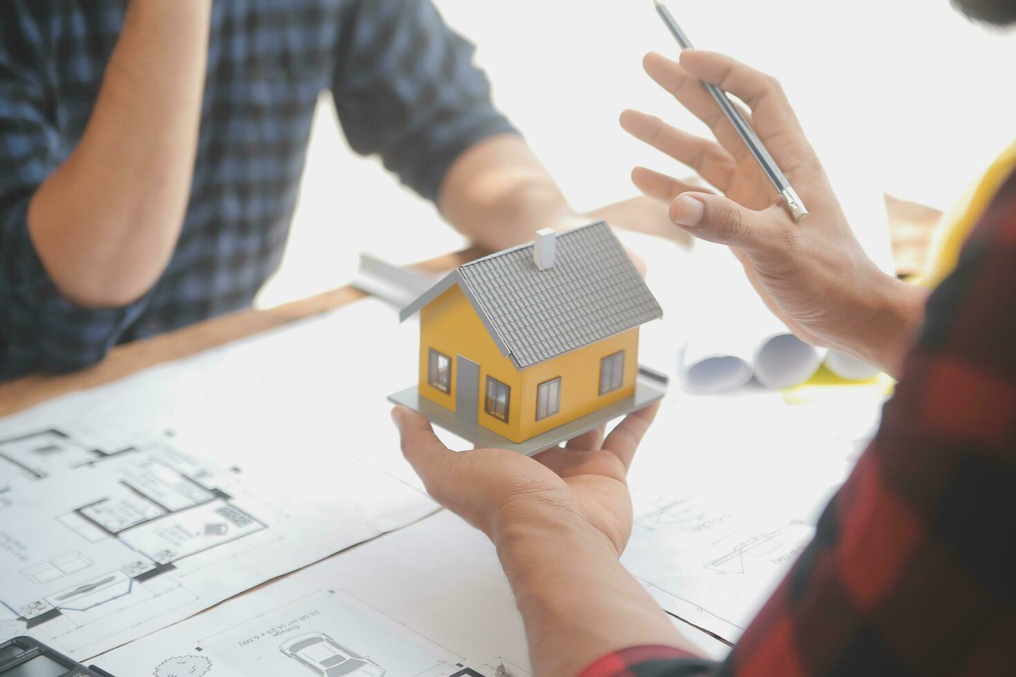 Close up of civil male engineer asian working on blueprint architectural project at construction site at desk in office. photo