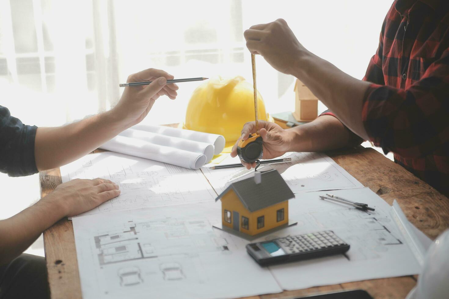 Close up of civil male engineer asian working on blueprint architectural project at construction site at desk in office. photo