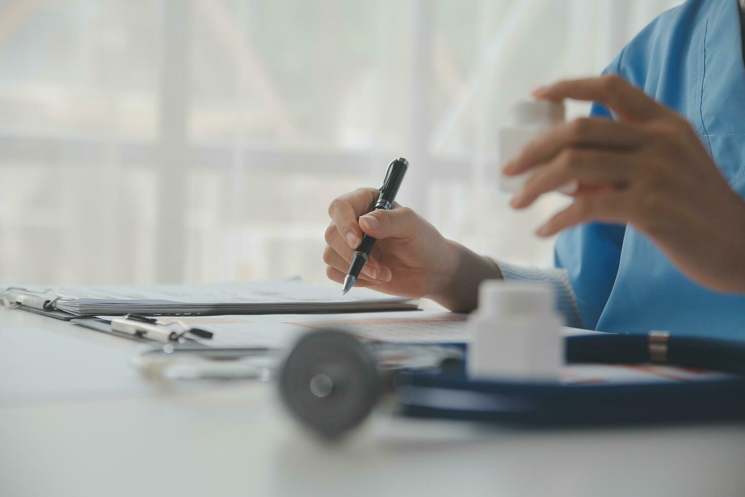 Stethoscope and background doctor using laptop at desk in clinic working on computer at room office. photo